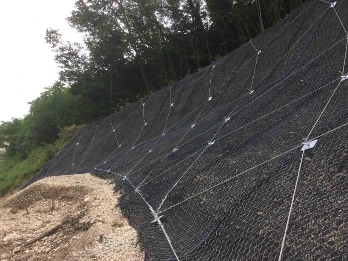 Geomat bonded to a double twisted metal mesh for rocky slopes